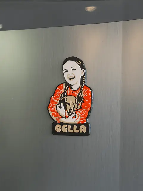 Chaveiro-retrato personalizado pendurado em uma geladeira, mostrando o uso real.