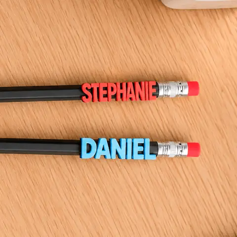 Nomes personalizados em 3D sobre lápis coloridos, lado a lado.